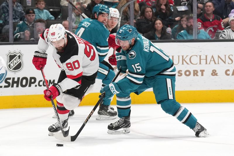 Jan 4, 2025; San Jose, California, USA; New Jersey Devils left wing Tomas Tatar (90) skates with the puck against San Jose Sharks right wing Nikolai Kovalenko (15) during the first period at SAP Center at San Jose. Mandatory Credit: Darren Yamashita-Imagn Images