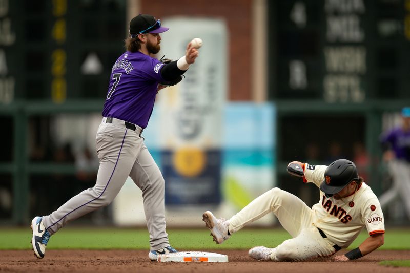 Jul 27, 2024; San Francisco, California, USA; Colorado Rockies second baseman Brendan Rodgers (7) throws over San Francisco Giants second baseman Brett Wisely (0) to complete a double play during the fourth inning at Oracle Park. Mandatory Credit: D. Ross Cameron-USA TODAY Sports