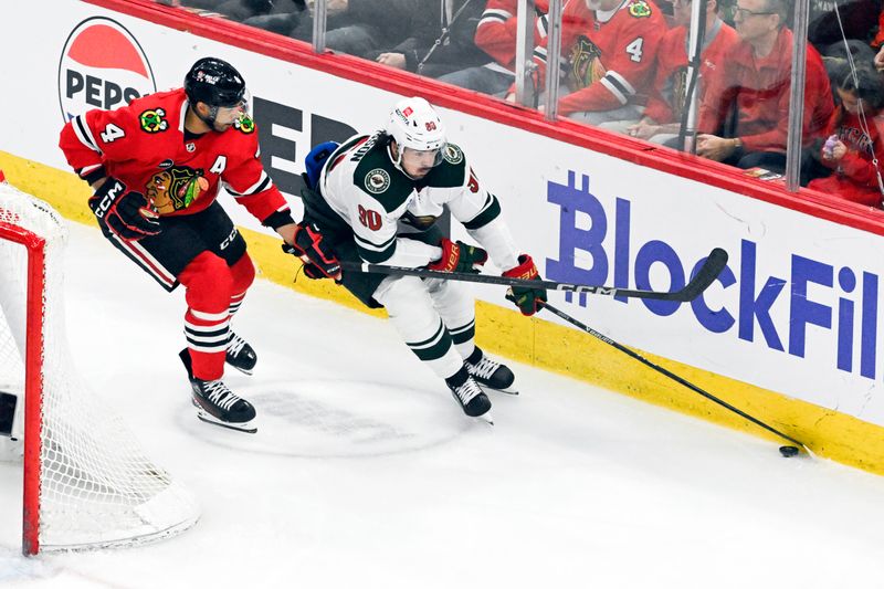 Apr 7, 2024; Chicago, Illinois, USA;  Chicago Blackhawks defenseman Seth Jones (4) and Minnesota Wild center Marcus Johansson (90) chase the puck during the first period at United Center. Mandatory Credit: Matt Marton-USA TODAY Sports