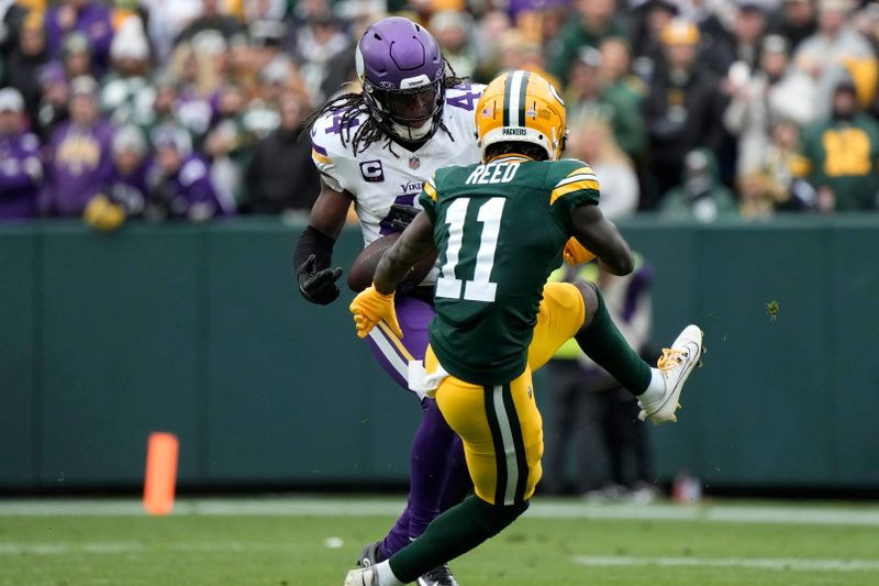 Minnesota Vikings safety Josh Metellus (44) intercepts a pass intended for Green Bay Packers wide receiver Jayden Reed (11) during the second half of an NFL football game Sunday, Oct. 29, 2023, in Green Bay, Wis. (AP Photo/Morry Gash)