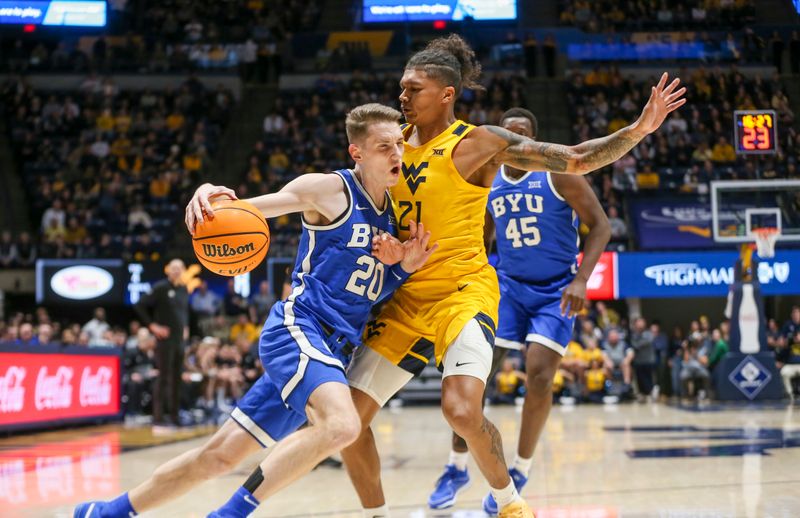 Feb 3, 2024; Morgantown, West Virginia, USA; Brigham Young Cougars guard Spencer Johnson (20) drives baseline against West Virginia Mountaineers guard RaeQuan Battle (21) during the first half at WVU Coliseum. Mandatory Credit: Ben Queen-USA TODAY Sports