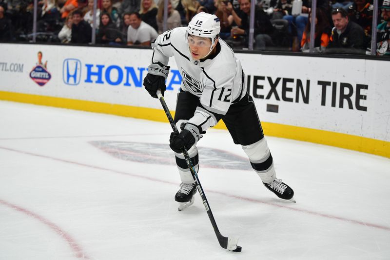 Nov 24, 2023; Anaheim, California, USA; Los Angeles Kings center Trevor Moore (12) moves the puck against the Anaheim Ducks during the first period at Honda Center. Mandatory Credit: Gary A. Vasquez-USA TODAY Sports