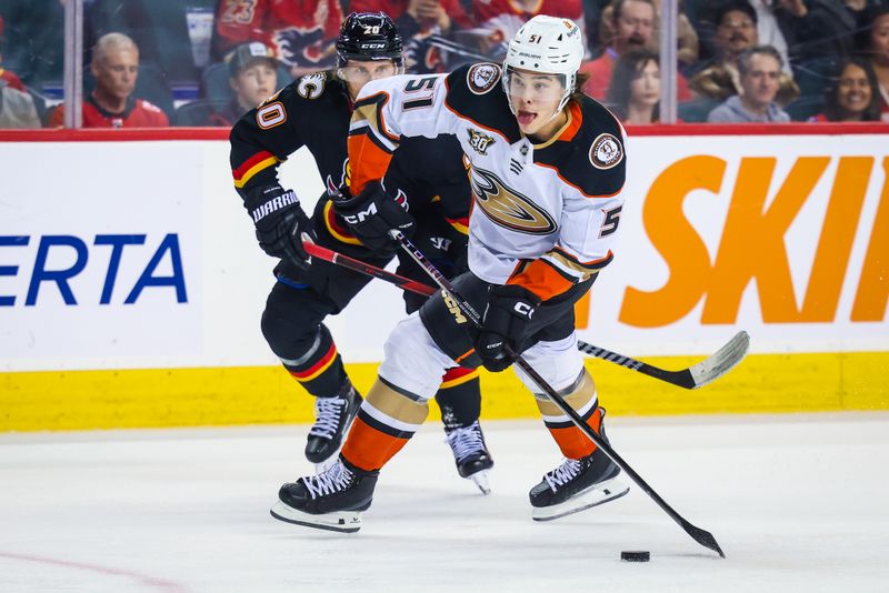 Apr 2, 2024; Calgary, Alberta, CAN; Anaheim Ducks defenseman Olen Zellweger (51) controls the puck against Calgary Flames center Blake Coleman (20) during the first period at Scotiabank Saddledome. Mandatory Credit: Sergei Belski-USA TODAY Sports