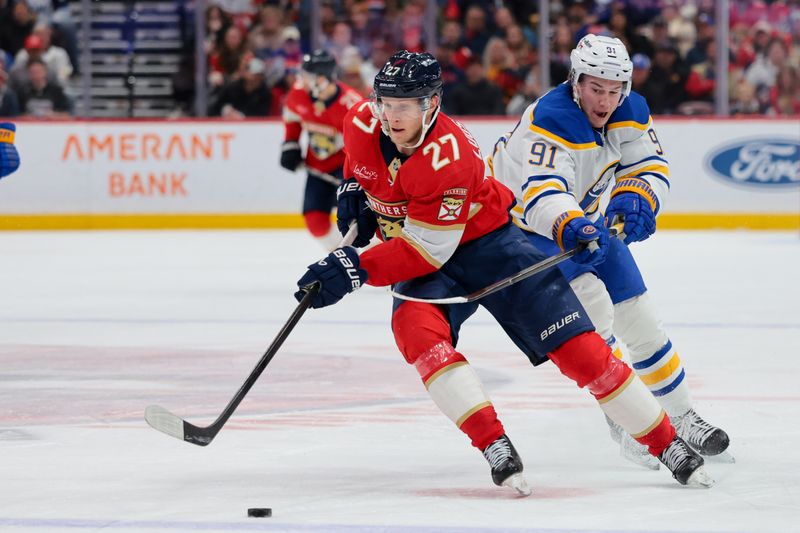 Feb 2, 2026; Sunrise, Florida, USA; Florida Panthers center Eetu Luostarinen (27) moves the puck against Buffalo Sabres right wing Josh Doan (91) during the third period at Amerant Bank Arena. Mandatory Credit: Sam Navarro-Imagn Images