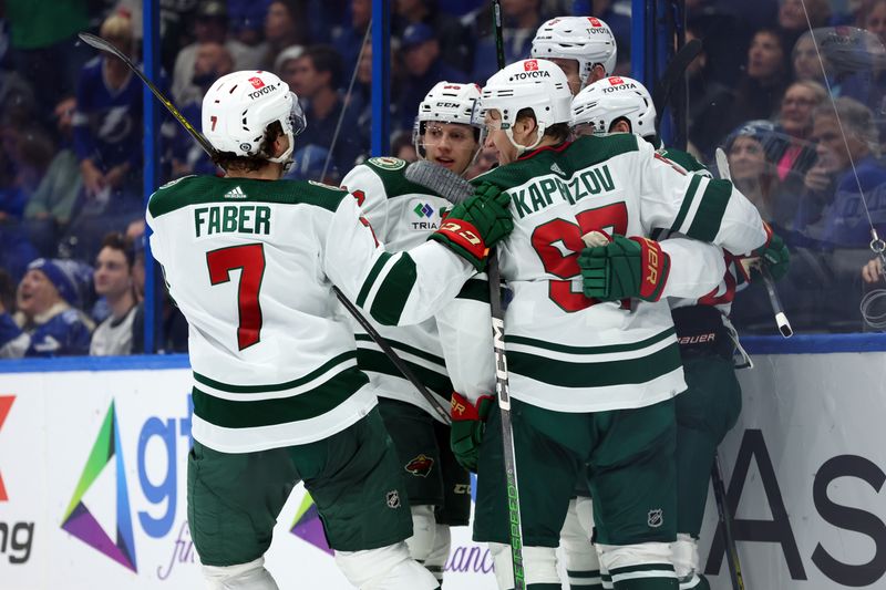 Jan 18, 2024; Tampa, Florida, USA; Minnesota Wild defenseman Jake Middleton (5) is congratulated after scoring against the Tampa Bay Lightning during the second period at Amalie Arena. Mandatory Credit: Kim Klement Neitzel-USA TODAY Sports