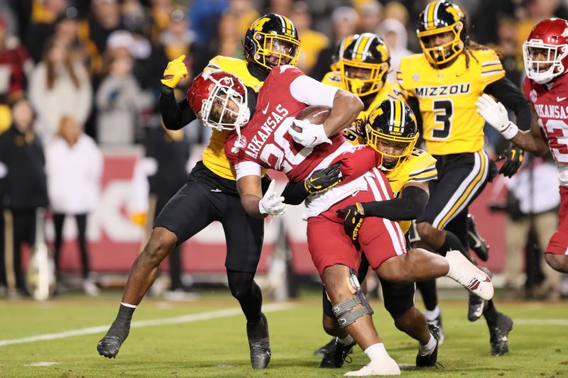 Nov 24, 2023; Fayetteville, Arkansas, USA; Arkansas Razorbacks running back Dominique Johnson (20) is tackled by Missouri Tigers defensive back Marcus Clarke (19) during the fourth quarter at Donald W. Reynolds Razorback Stadium. Missouri won 48-14. Mandatory Credit: Nelson Chenault-USA TODAY Sports