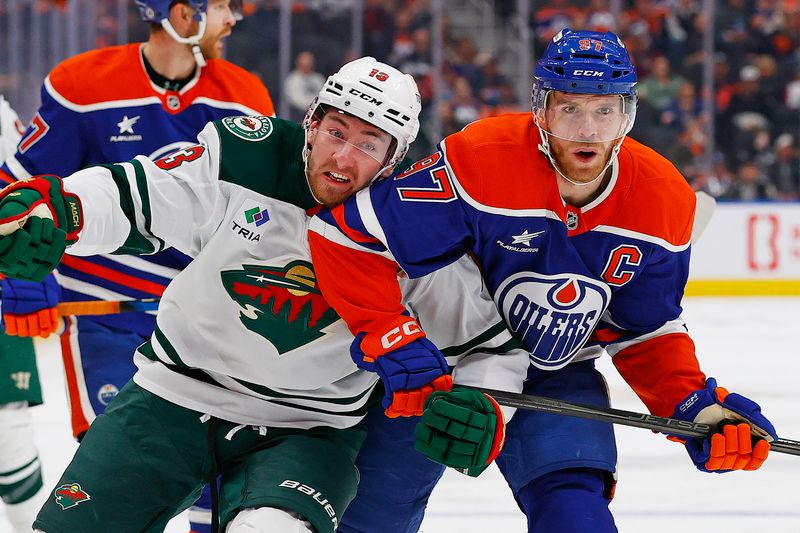 Nov 21, 2024; Edmonton, Alberta, CAN; Edmonton Oilers forward Connor McDavid (97) and Minnesota Wild forward Yakov Trenin (13) battle for position during the second period at Rogers Place. Mandatory Credit: Perry Nelson-Imagn Images