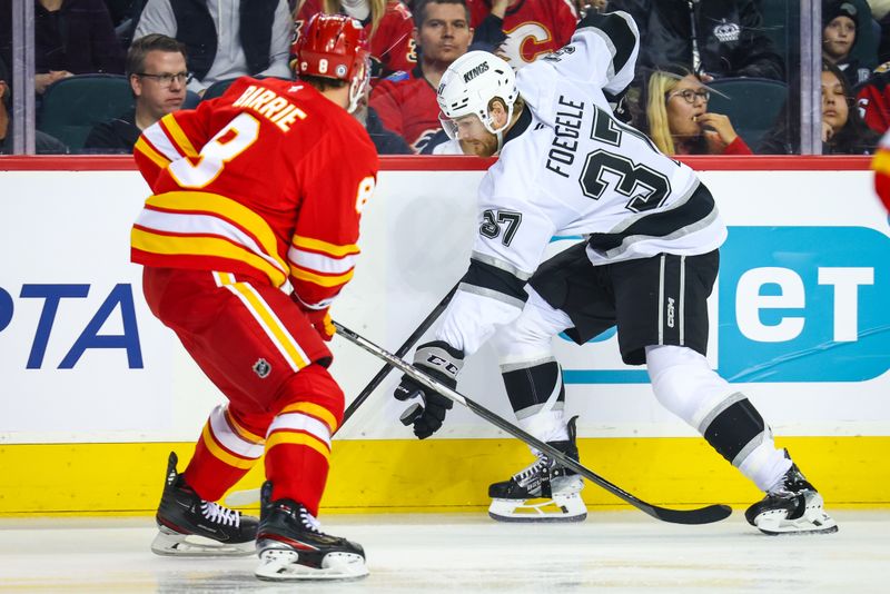 Nov 11, 2024; Calgary, Alberta, CAN; Los Angeles Kings left wing Warren Foegele (37) controls the puck against Calgary Flames defenseman Tyson Barrie (8) during the first period at Scotiabank Saddledome. Mandatory Credit: Sergei Belski-Imagn Images