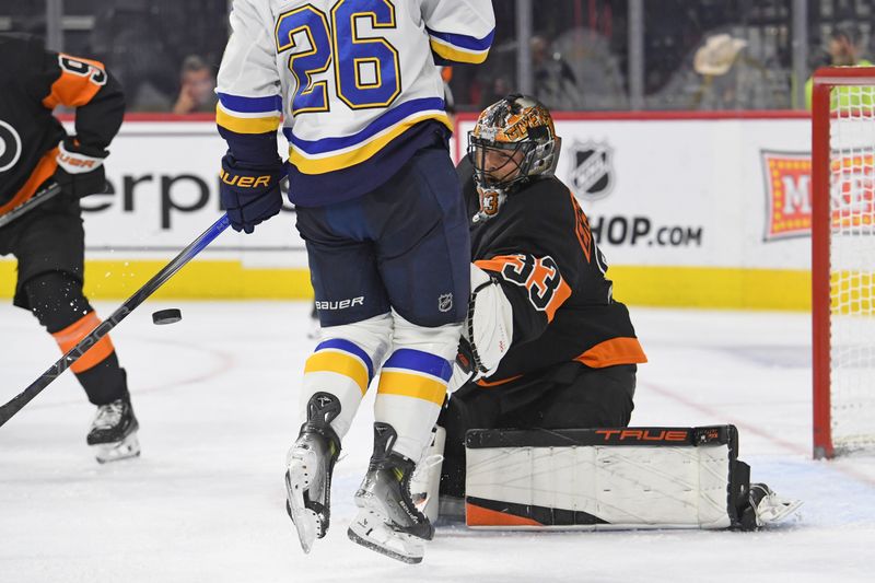 Oct 31, 2024; Philadelphia, Pennsylvania, USA; St. Louis Blues left wing Nathan Walker (26) jumps out of the way of the puck in front of Philadelphia Flyers goaltender Samuel Ersson (33) during the second period at Wells Fargo Center. Mandatory Credit: Eric Hartline-Imagn Images