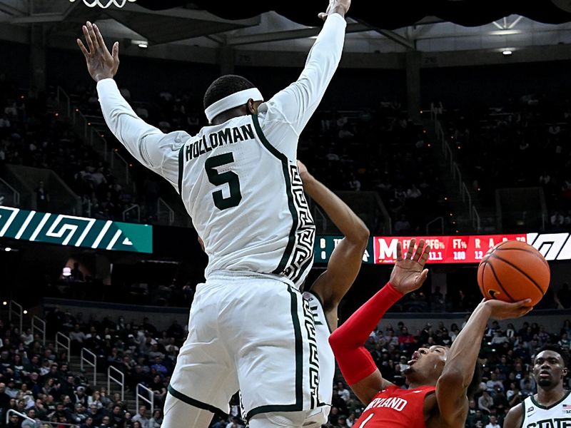 Feb 7, 2023; East Lansing, Michigan, USA;  Maryland Terrapins guard Jahmir Young (1) shoots off-balance in the first half against Michigan State Spartans guard Tre Holloman (5) at Jack Breslin Student Events Center. Mandatory Credit: Dale Young-USA TODAY Sports