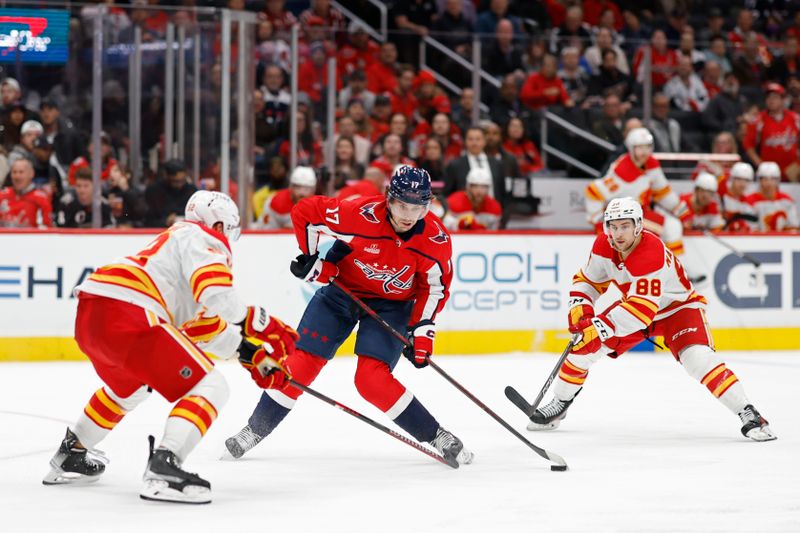 Oct 16, 2023; Washington, District of Columbia, USA; Washington Capitals center Dylan Strome (17) shoots the puck as Calgary Flames defenseman MacKenzie Weegar (52) and Flames left wing Andrew Mangiapane (88) defend in the third period at Capital One Arena. Mandatory Credit: Geoff Burke-USA TODAY Sports