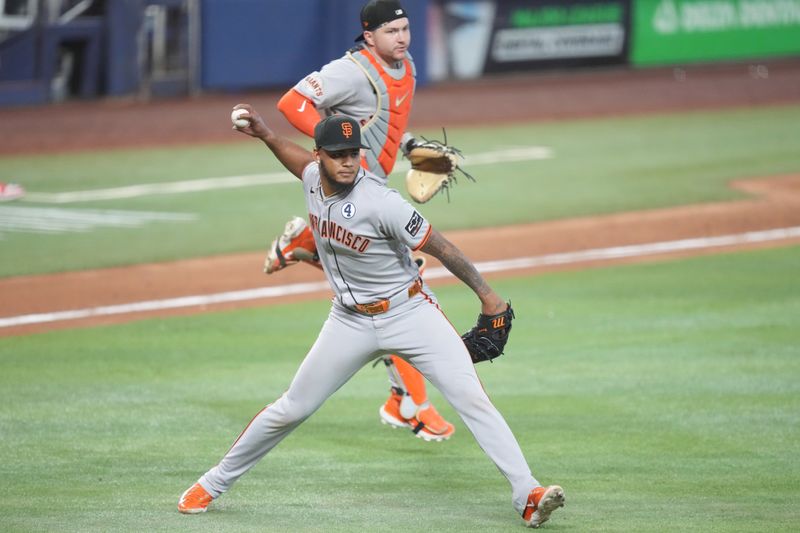 Jun 1, 2025; Miami, Florida, USA;  San Francisco Giants pitcher Camilo Doval (75) fields a ground ball and throws to first base to end the game against the Miami Marlins at loanDepot Park. Mandatory Credit: Jim Rassol-Imagn Images