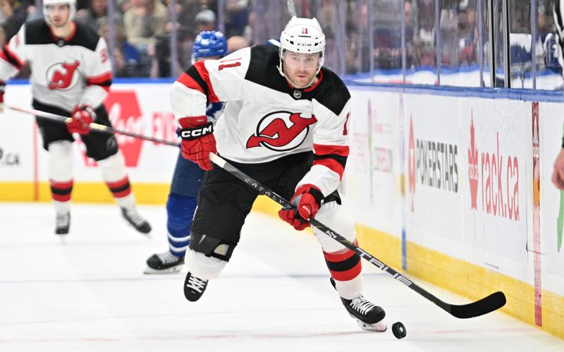 Apr 11, 2024; Toronto, Ontario, CAN; New Jersey Devils forward Chris Tierney (11) skates with the puck against the Toronto Maple Leafs in the second period at Scotiabank Arena. Mandatory Credit: Dan Hamilton-USA TODAY Sports