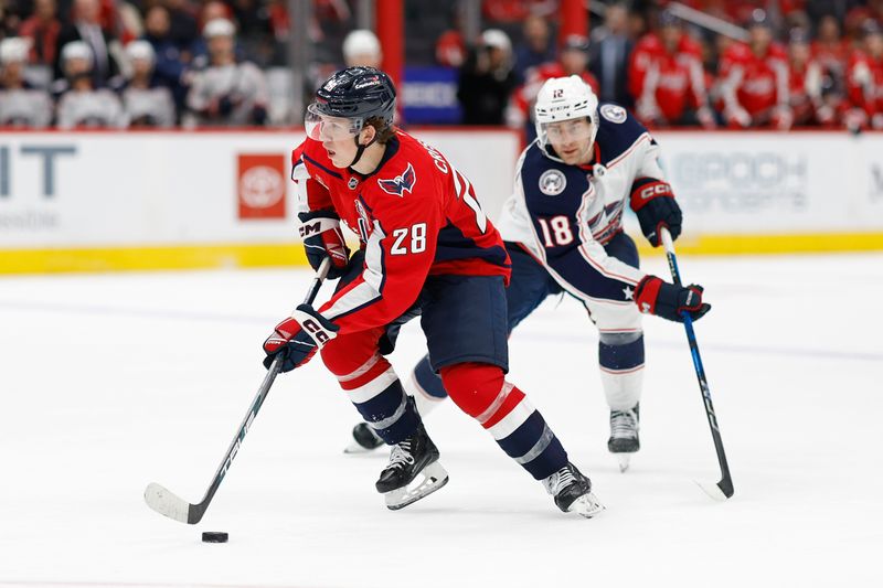 Sep 27, 2024; Washington, District of Columbia, USA; Washington Capitals forward Andrew Cristell (28) skates with the puck as Columbus Blue Jackets center Dylan Gambrell (18) chases in the third period at Capital One Arena. Mandatory Credit: Geoff Burke-Imagn Images