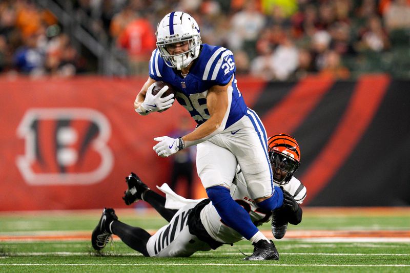 Indianapolis Colts running back Evan Hull (26) tries to break a tackle by Cincinnati Bengals safety Jordan Battle during the first half of a preseason NFL football game, Thursday, Aug. 22, 2024, in Cincinnati. (AP Photo/Jeff Dean)