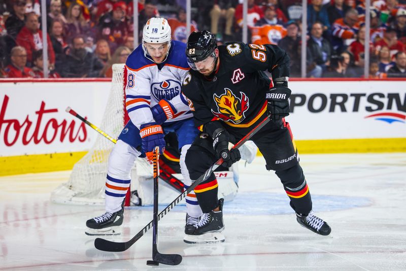 Apr 6, 2024; Calgary, Alberta, CAN; Edmonton Oilers left wing Zach Hyman (18) and Calgary Flames defenseman MacKenzie Weegar (52) battles for the puck during the third period at Scotiabank Saddledome. Mandatory Credit: Sergei Belski-USA TODAY Sports