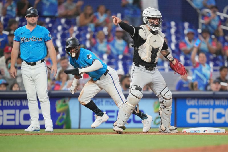 Jul 7, 2024; Miami, Florida, USA;  Chicago White Sox catcher Korey Lee (26) directs someone to cover home plate after a bunt left him at third base as Miami Marlins shortstop Vidal Bruján (17) rounds third base in the ninth inning at loanDepot Park. Mandatory Credit: Jim Rassol-USA TODAY Sports