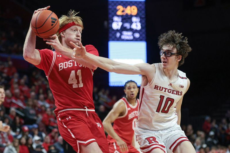 Nov 10, 2023; Piscataway, New Jersey, USA; Boston University Terriers forward Otto Landrum (41) grabs the ball in front of Rutgers Scarlet Knights guard Gavin Griffiths (10) during the second half at Jersey Mike's Arena. Mandatory Credit: Vincent Carchietta-USA TODAY Sports