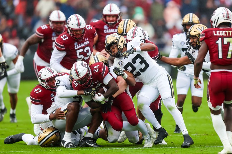 Nov 11, 2023; Columbia, South Carolina, USA; South Carolina Gamecocks running back Mario Anderson (24) is stopped by several Vanderbilt Commodores tacklers in the first quarter at Williams-Brice Stadium. Mandatory Credit: Jeff Blake-USA TODAY Sports