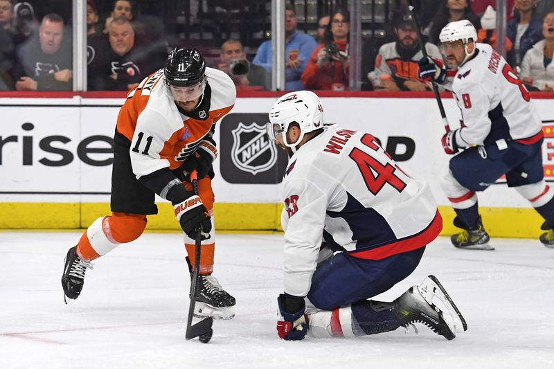 Oct 22, 2024; Philadelphia, Pennsylvania, USA; Philadelphia Flyers right wing Travis Konecny (11) and Washington Capitals right wing Tom Wilson (43) battle for the puck during the second period at Wells Fargo Center. Mandatory Credit: Eric Hartline-Imagn Images