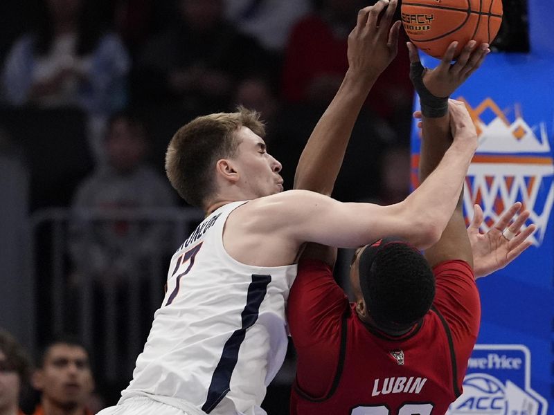 Mar 12, 2026; Charlotte, NC, USA;  Virginia Cavaliers center Johann Grünloh (17) blocks a shot by NC State Wolfpack forward Ven-Allen Lubin (22) during the first half at Spectrum Center. Mandatory Credit: Jim Dedmon-Imagn Images