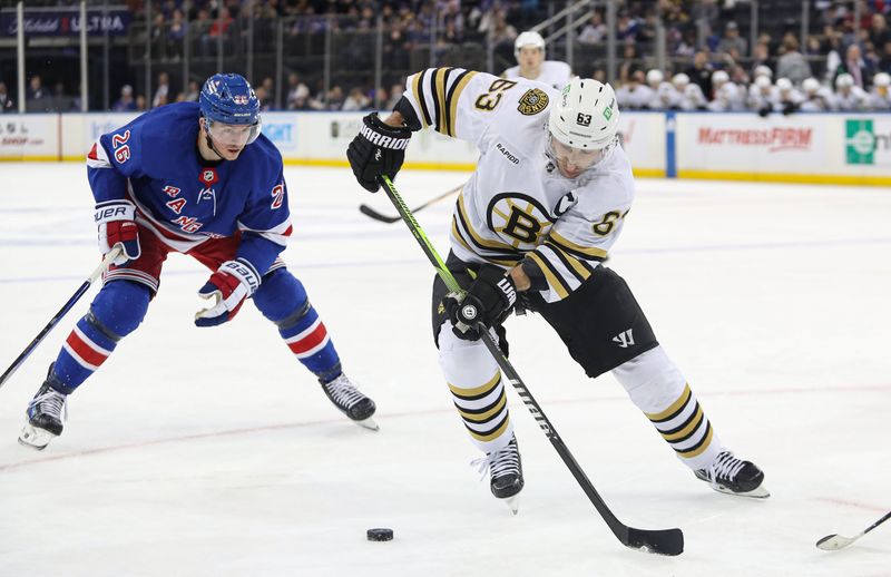 Nov 25, 2023; New York, New York, USA; Boston Bruins left wing Brad Marchand (63) plays the puck in front of New York Rangers left wing Jimmy Vesey (26) during the third period at Madison Square Garden. Mandatory Credit: Danny Wild-USA TODAY Sports