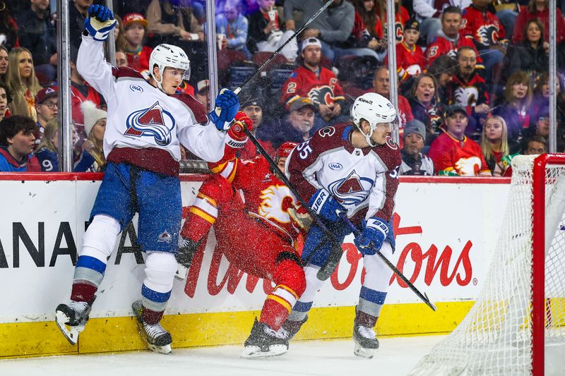 Mar 14, 2025; Calgary, Alberta, CAN; Colorado Avalanche defenseman Josh Manson (42) checks into the boards Calgary Flames left wing Ryan Lomberg (70) during the second period at Scotiabank Saddledome. Mandatory Credit: Sergei Belski-Imagn Images