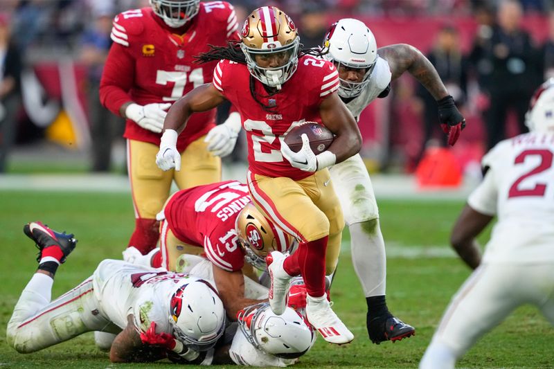 San Francisco 49ers running back Jordan Mason (24) runs against the Arizona Cardinals during the second half of an NFL football game Sunday, Dec. 17, 2023, in Glendale, Ariz. (AP Photo/Matt York)