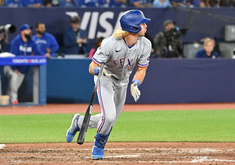 Sep 12, 2023; Toronto, Ontario, CAN;  Texas Rangers right fielder Travis Jankowski (16) hits an RBI single against the Toronto Blue Jays in the ninth inning at Rogers Centre. Mandatory Credit: Dan Hamilton-USA TODAY Sports