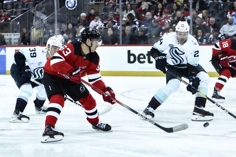 Feb 12, 2024; Newark, New Jersey, USA; New Jersey Devils left wing Jesper Bratt (63) passes the puck while being defended by Seattle Kraken defenseman Ryker Evans (39) and Seattle Kraken defenseman Jamie Oleksiak (24) during the second period at Prudential Center. Mandatory Credit: John Jones-USA TODAY Sports