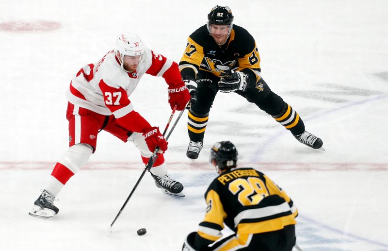 Mar 17, 2024; Pittsburgh, Pennsylvania, USA;  Detroit Red Wings left wing J.T. Compher (37) passes the puck as Pittsburgh Penguins center Sidney Crosby (87) and defenseman Marcus Pettersson (28) defend during the third period at PPG Paints Arena. Pittsburgh won 6-3. Mandatory Credit: Charles LeClaire-USA TODAY Sports