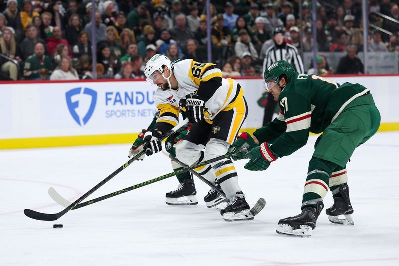 Oct 30, 2025; Saint Paul, Minnesota, USA; Pittsburgh Penguins defenseman Erik Karlsson (65) skates with the puck alongside Minnesota Wild left wing Marcus Foligno (17) during the third period at Grand Casino Arena. Mandatory Credit: Matt Krohn-Imagn Images