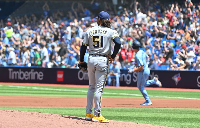 Jun 1, 2023; Toronto, Ontario, CAN;  Milwaukee Brewers starting pitcher Freddy Peralta (51) watches Toronto Blue Jays third baseman Matt Chapman (26) round the bases after hitting a two run home run in the first inning at Rogers Centre. Mandatory Credit: Dan Hamilton-USA TODAY Sports