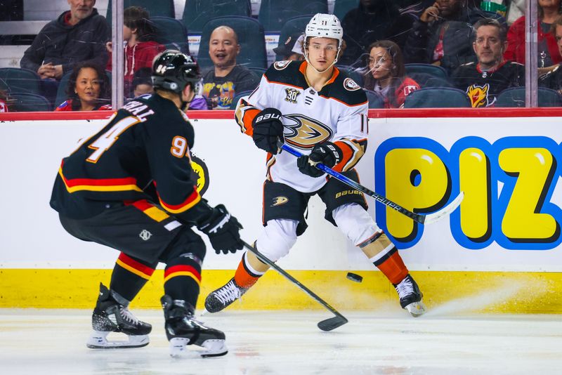 Apr 2, 2024; Calgary, Alberta, CAN; Anaheim Ducks center Trevor Zegras (11) and Calgary Flames defenseman Brayden Pachal (94) battles for the puck during the second period at Scotiabank Saddledome. Mandatory Credit: Sergei Belski-USA TODAY Sports