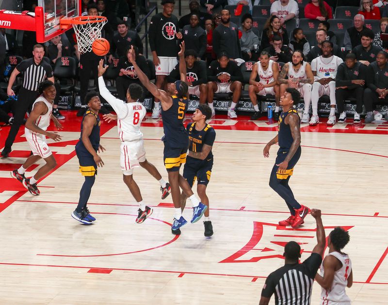 Jan 15, 2025; Houston, Texas, USA; Houston Cougars guard Mylik Wilson (8) is fouled by West Virginia Mountaineers guard Toby Okani (5) in the second half at Fertitta Center. Mandatory Credit: Thomas Shea-Imagn Images