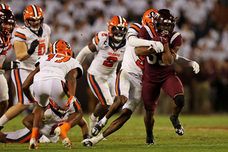 Oct 26, 2023; Blacksburg, Virginia, USA; Virginia Tech Hokies running back Bhayshul Tuten (33) runs the ball against Syracuse Orange defensive back Alijah Clark (5) during the third quarter at Lane Stadium. Mandatory Credit: Peter Casey-USA TODAY Sports