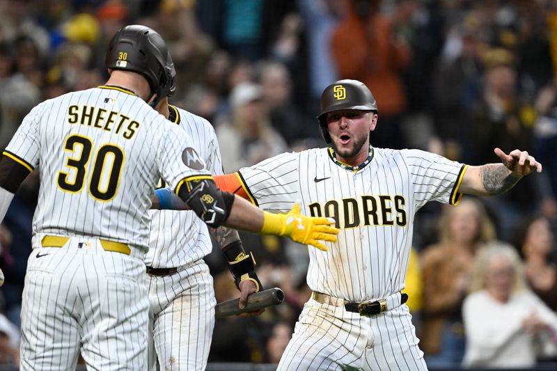 May 12, 2025; San Diego, California, USA; San Diego Padres center fielder Jackson Merrill (3) is congratulated by Gavin Sheets (30) after scoring during the third inning against the Los Angeles Angels at Petco Park. Mandatory Credit: Denis Poroy-Imagn Images