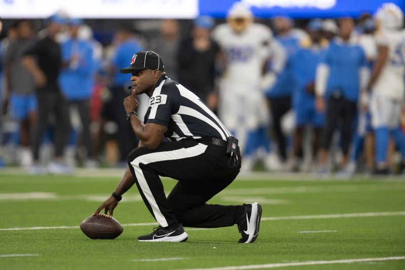 Field judge Tra Boger (23) measures the ball during an NFL preseason football game between the Los Angeles Rams and the Los Angeles Chargers, Saturday, Aug. 12, 2023, in Inglewood, Calif. (AP Photo/Kyusung Gong)