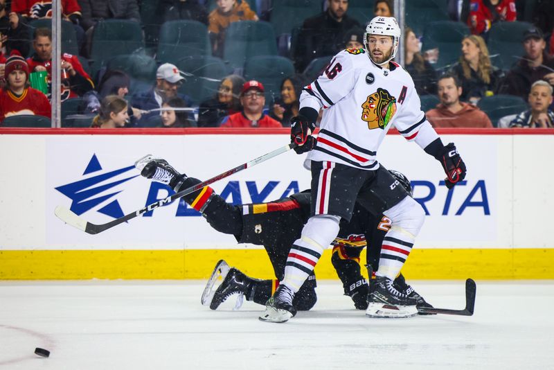 Jan 27, 2024; Calgary, Alberta, CAN; Chicago Blackhawks center Jason Dickinson (16) and Calgary Flames right wing Matt Coronato (27) battles for the puck during the second period at Scotiabank Saddledome. Mandatory Credit: Sergei Belski-USA TODAY Sports