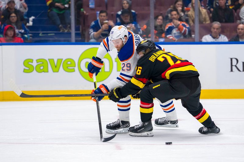 Nov 9, 2024; Vancouver, British Columbia, CAN; Vancouver Canucks defenseman Erik Brannstrom (26) stick checks Edmonton Oilers forward Leon Draisaitl (29) during the first period at Rogers Arena. Mandatory Credit: Bob Frid-Imagn Images