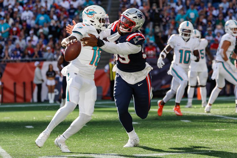 New England Patriots defensive end Keion White (99) attempts to sack Miami Dolphins quarterback Tyler Huntley (18) on a two point conversion during the second half of an NFL football game on Sunday, Oct. 6, 2024, in Foxborough, Mass. The Miami Dolphins won 15-10. (AP Photo/Greg M. Cooper)