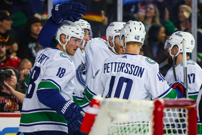 Dec 2, 2023; Calgary, Alberta, CAN; Vancouver Canucks center Sam Lafferty (18) celebrates his goal with teammates against the Calgary Flames during the first period at Scotiabank Saddledome. Mandatory Credit: Sergei Belski-USA TODAY Sports