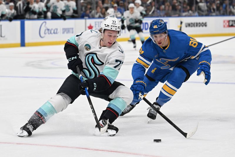 Nov 8, 2025; St. Louis, Missouri, USA; Seattle Kraken center Berkly Catton (77) and St. Louis Blues left wing Dylan Holloway (81) battle for the puck in the first period at Enterprise Center. Mandatory Credit: Joe Puetz-Imagn Images