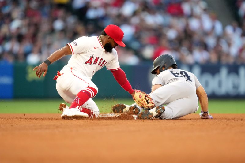 May 28, 2025; Anaheim, California, USA; New York Yankees left fielder Jasson Dominguez (24) slides into second base to beat a throw to Los Angeles Angels second baseman Luis Rengifo (2) for a stolen base in the third inning at Angel Stadium. Mandatory Credit: Kirby Lee-Imagn Images