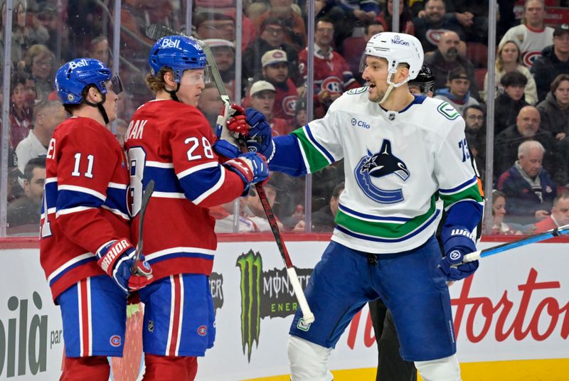 Jan 6, 2025; Montreal, Quebec, CAN; Montreal Canadiens forward Brendan Gallagher (11) and teammate forward Christian Dvorak (28) and Vancouver Canucks defenseman Vincent Desharnais (73) during the second period at the Bell Centre. Mandatory Credit: Eric Bolte-Imagn Images