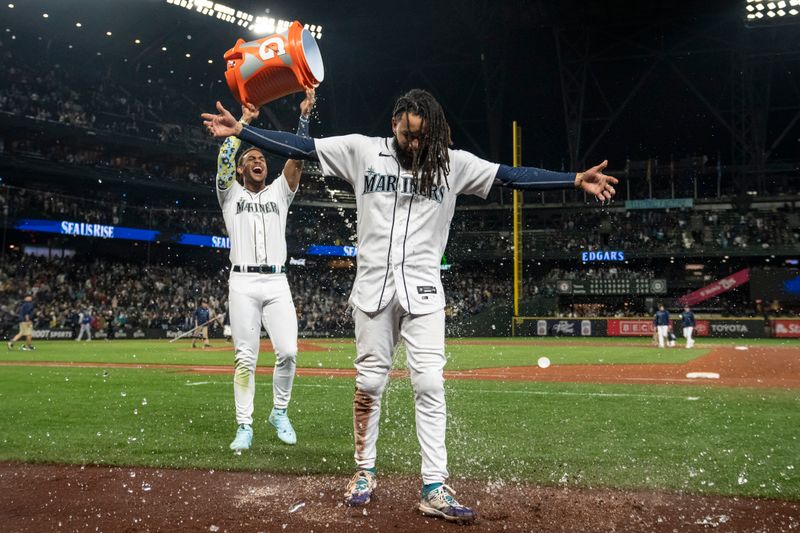 Sep 28, 2023; Seattle, Washington, USA; Seattle Mariners centerfielder Julio Rodriguez (44) dumps a bucket of water on shortstop J.P. Crawford (3) while celebrating after a game against the Texas Rangers at T-Mobile Park. Mandatory Credit: Stephen Brashear-USA TODAY Sports