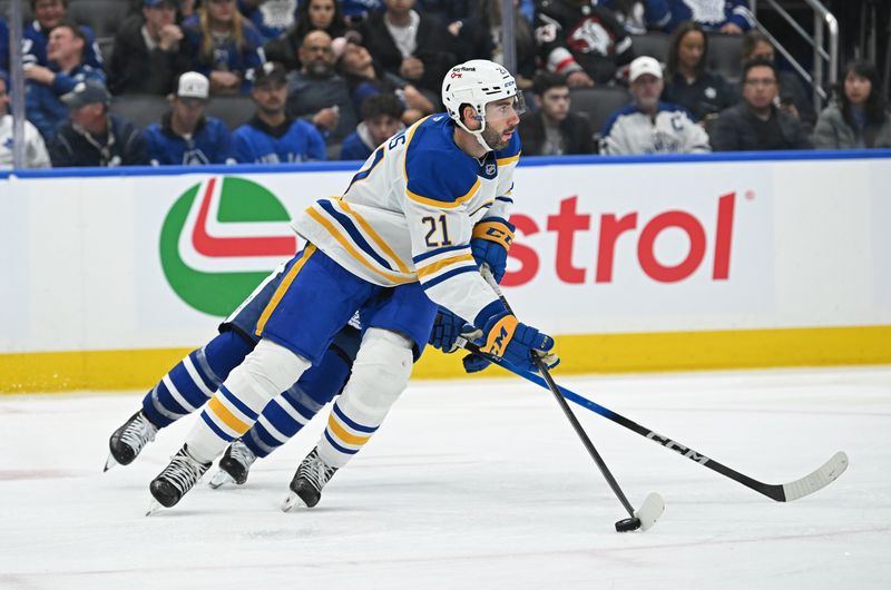 Oct 25, 2025; Toronto, Ontario, CAN; Buffalo Sabres defenceman Conor Timmins (21) carries the puck against the Toronto Maple Leafs in the third period at Scotiabank Arena. Mandatory Credit: Gerry Angus-Imagn Images