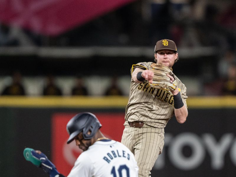 Sep 11, 2024; Seattle, Washington, USA;  San Diego Padres second baseman turns a double play after forcing out Seattle Mariners left fielder Victor Robles (10) at second base at T-Mobile Park. Mandatory Credit: Stephen Brashear-Imagn Images