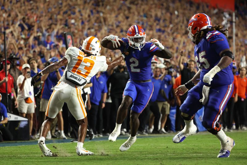 Sep 16, 2023; Gainesville, Florida, USA; Florida Gators running back Montrell Johnson Jr. (2) runs the ball past Tennessee Volunteers defensive back Wesley Walker (13) in for a touchdown against the Tennessee Volunteers  during the second quarter at Ben Hill Griffin Stadium. Mandatory Credit: Kim Klement Neitzel-USA TODAY Sports