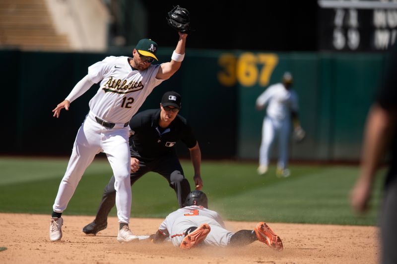 Jul 7, 2024; Oakland, California, USA; Baltimore Orioles pinch runner Jorge Mateo (3) slides safely into second base with a steal ahead of the tag by Oakland Athletics shortstop Max Schuemann (12) during the ninth inning at Oakland-Alameda County Coliseum. Mandatory Credit: D. Ross Cameron-USA TODAY Sports